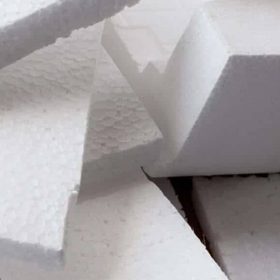 Closeup white polystyrene foam on the cardboard. Polystyrene foam is cushioning material in packaging, material for craft applications and other
